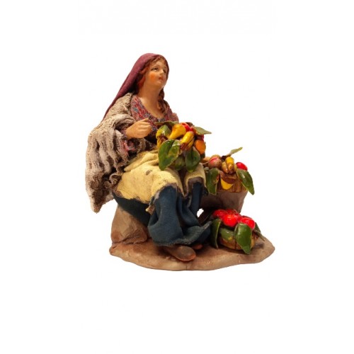 Donna seduta con cesti di frutta...