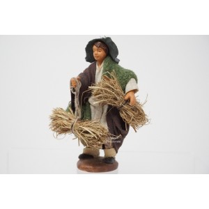 Uomo con fascine di fieno...